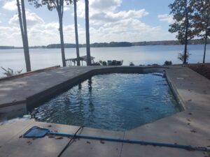 an inground pool installed by Kirk's Pool and Hearth that overlooks a beautiful lake