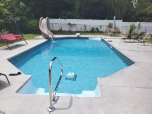 a custom inground pool from Kirk's Pool and Hearth shining in the summer sun