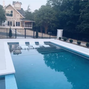 a stunning inground fiberglass pool in the foreground and a beautiful home in the background