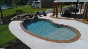 a custom inground vinyl pool with a rock waterfall feature