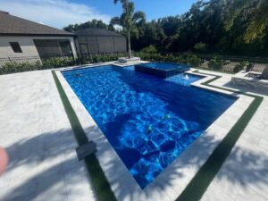 A beautiful fiberglass inground pool installed by Kirk's Pool and Hearth shining in the afternoon sun