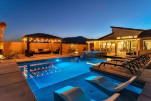 a gorgeous custom inground pool installed by Kirk's Pool and Hearth, pictured at twilight