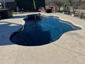 one of Kirk's Pool and Hearth's custom pool designs. it has asymmetrical curves and a unique shape